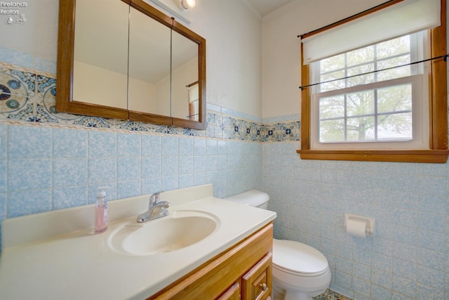 419 Kinney St, Bellevue, OH 44811 - bathroom with toilet, vanity, tile walls, and a wainscoted wall