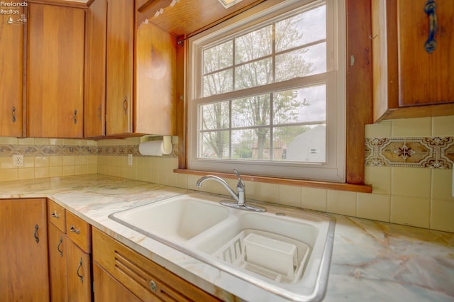 419 Kinney St, Bellevue, OH 44811 - kitchen with a sink, light countertops, backsplash, and brown cabinets