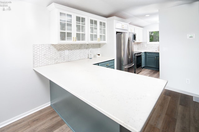 6039 E Harbor Rd Unit 8, Marblehead, OH 43440 - kitchen featuring appliances with stainless steel finishes, white cabinetry, light wood-style flooring, vaulted ceiling, and backsplash