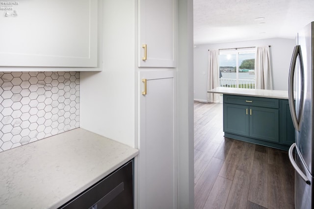 6039 E Harbor Rd Unit 8, Marblehead, OH 43440 - kitchen with freestanding refrigerator, dark wood-type flooring, white cabinets, light stone countertops, and tasteful backsplash