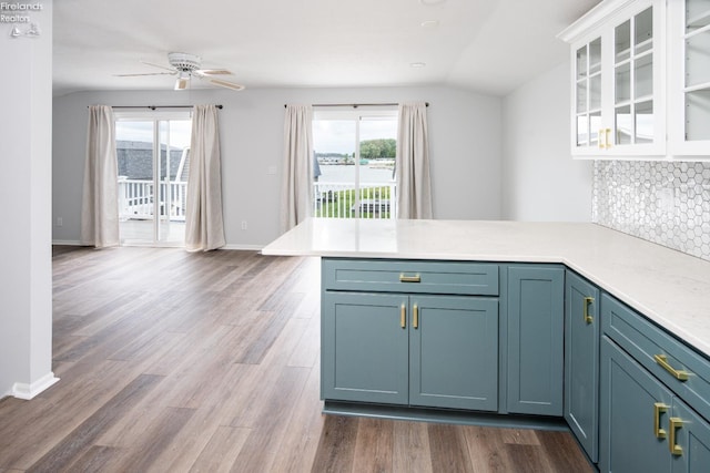6039 E Harbor Rd Unit 8, Marblehead, OH 43440 - kitchen featuring a peninsula, plenty of natural light, tasteful backsplash, glass insert cabinets, and vaulted ceiling