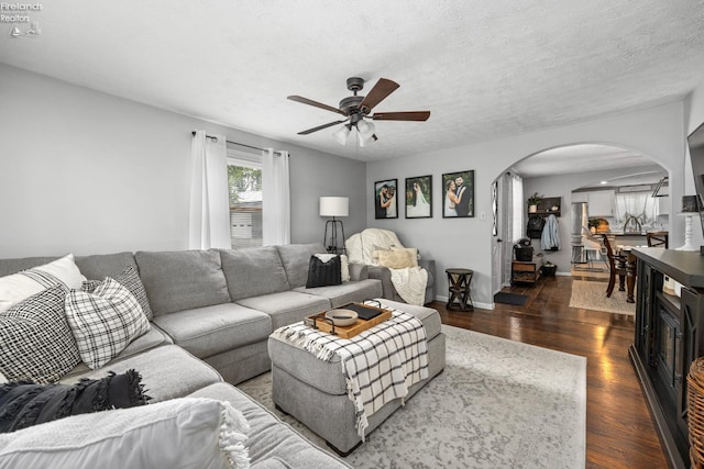 3960 Everingin Rd, Monroeville, OH 44847 - living area featuring arched walkways, a ceiling fan, dark wood-type flooring, and a textured ceiling