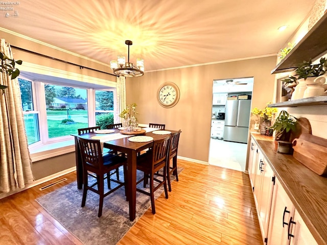 1432 River Dr, Fremont, OH 43420 - dining room featuring a chandelier, crown molding, and light wood-style floors