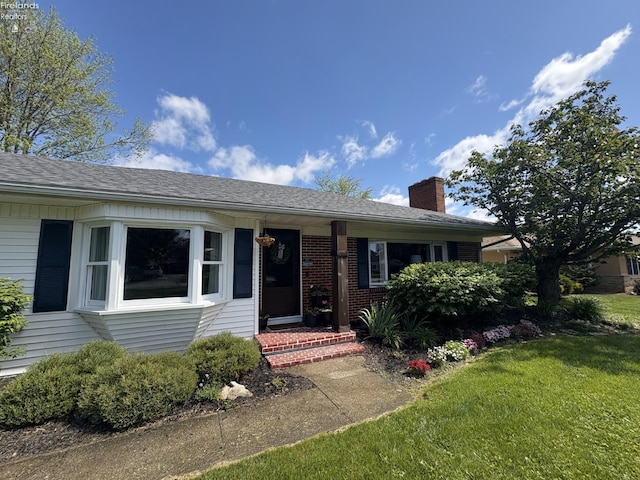 1432 River Dr, Fremont, OH 43420 - view of front facade featuring a chimney, a front lawn, and brick siding