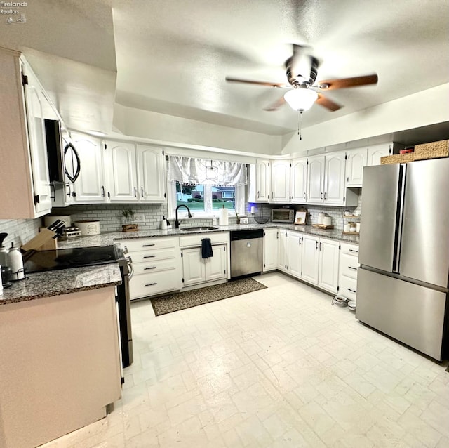 1432 River Dr, Fremont, OH 43420 - kitchen featuring appliances with stainless steel finishes, a sink, a ceiling fan, decorative backsplash, and white cabinetry