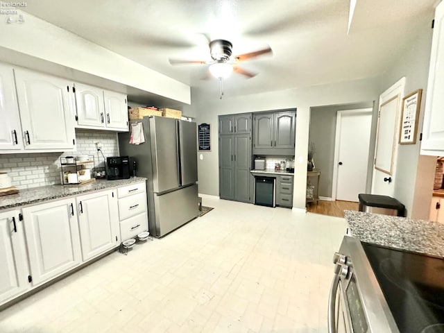 1432 River Dr, Fremont, OH 43420 - kitchen with ceiling fan, tasteful backsplash, stainless steel appliances, light stone countertops, and white cabinetry
