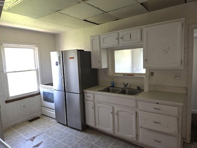 91 1st Ave, Tiffin, OH 44883 - kitchen with a sink, freestanding refrigerator, white cabinets, a drop ceiling, and light countertops