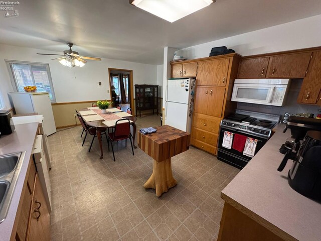 104 N Wood St, Fremont, OH 43420 - kitchen with white appliances, light flooring, ceiling fan, a sink, and brown cabinetry