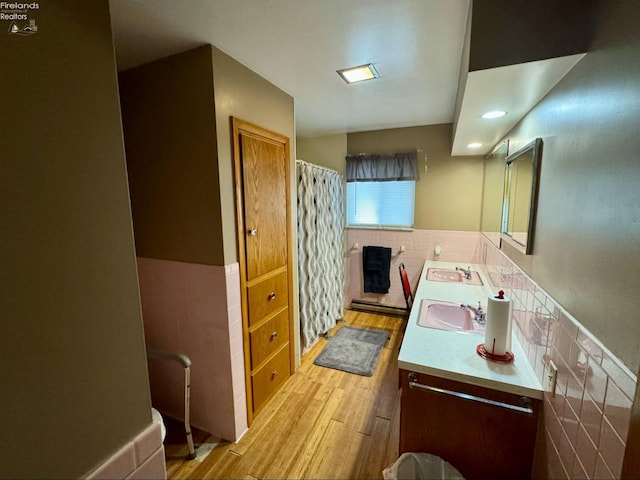 104 N Wood St, Fremont, OH 43420 - bathroom with wood finished floors, double vanity, tile walls, a shower with curtain, and wainscoting