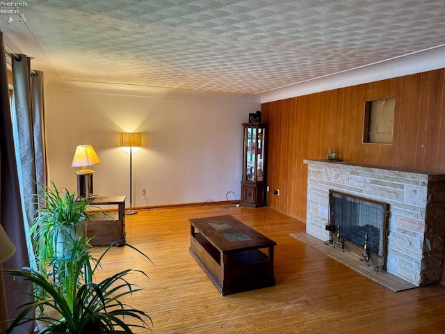 104 N Wood St, Fremont, OH 43420 - living area featuring light wood finished floors, a fireplace, wooden walls, and baseboards