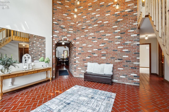 2203 Eagles Nest Cir, Sandusky, OH 44870 - interior space featuring brick flooring, a towering ceiling, arched walkways, stairs, and brick wall