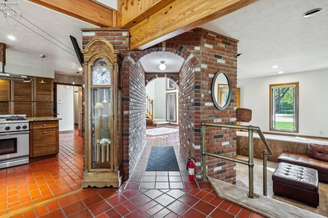 2203 Eagles Nest Cir, Sandusky, OH 44870 - kitchen with stainless steel gas stove, tile patterned flooring, a textured ceiling, and arched walkways