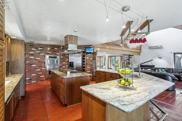 2203 Eagles Nest Cir, Sandusky, OH 44870 - kitchen featuring appliances with stainless steel finishes, a spacious island, brown cabinets, a sink, and brick flooring