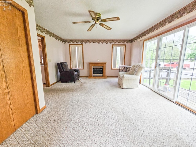 124 Walter St, Bellevue, OH 44811 - living area with carpet flooring, a glass covered fireplace, a ceiling fan, and baseboards