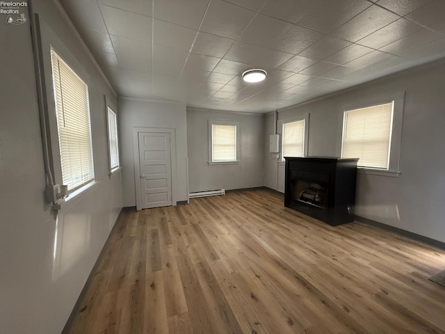 118 E 5th St, Port Clinton, OH 43452 - unfurnished living room with baseboard heating, wood finished floors, a fireplace, and baseboards