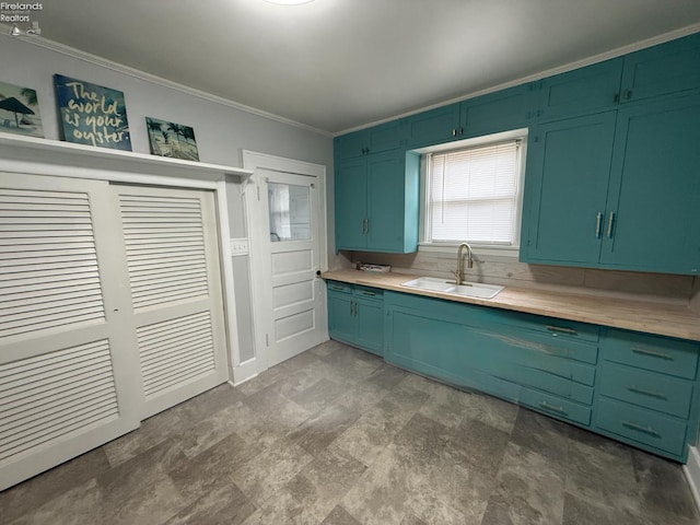 118 E 5th St, Port Clinton, OH 43452 - kitchen featuring a sink, ornamental molding, light countertops, stone finish floors, and green cabinets