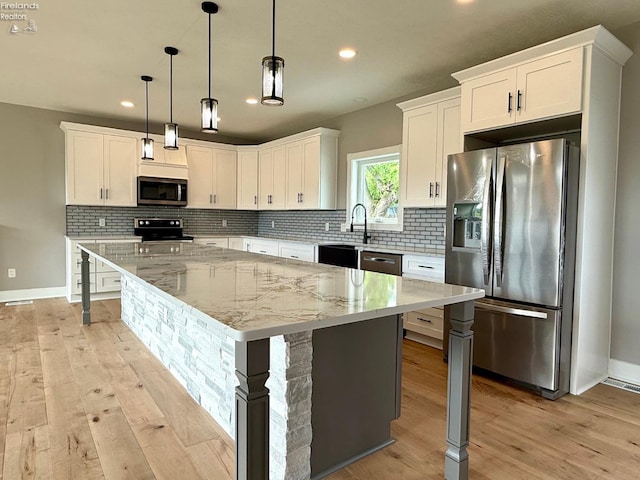 10556 E Bayshore Rd Unit 4C, Marblehead, OH 43440 - kitchen featuring appliances with stainless steel finishes, light wood-type flooring, a kitchen island, white cabinetry, and recessed lighting