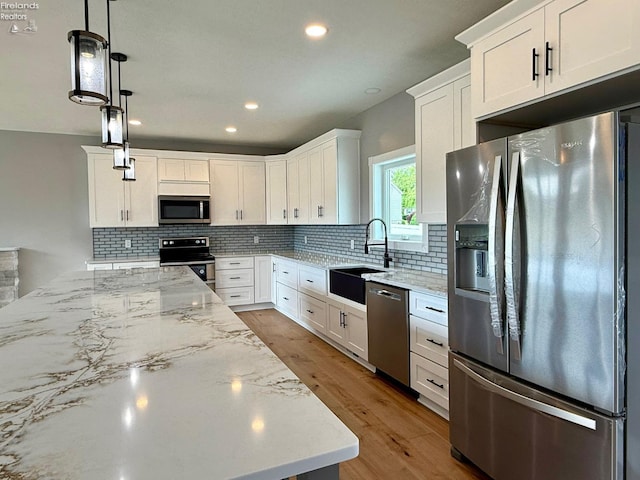 10556 E Bayshore Rd Unit 4C, Marblehead, OH 43440 - kitchen featuring stainless steel appliances, a sink, light stone counters, white cabinetry, and tasteful backsplash