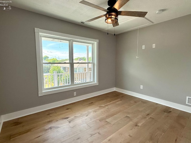 10556 E Bayshore Rd Unit 4C, Marblehead, OH 43440 - unfurnished room featuring ceiling fan, wood finished floors, baseboards, attic access, and a textured ceiling