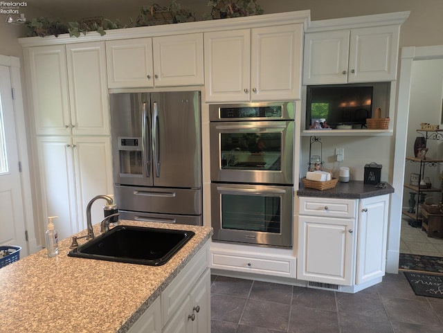 508 Snowy Egret Dr, Huron, OH 44839 - kitchen featuring stainless steel appliances, a sink, white cabinets, and light stone counters