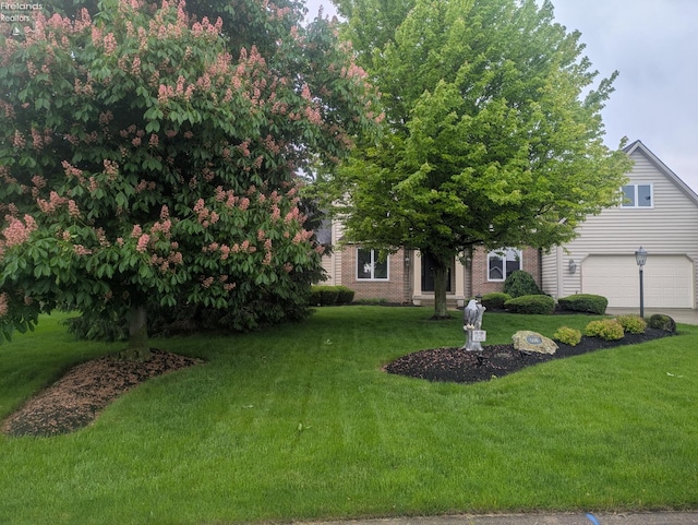 508 Snowy Egret Dr, Huron, OH 44839 - obstructed view of property featuring a front lawn, brick siding, and driveway