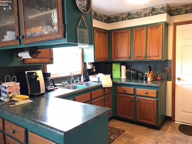 87 E Township Road 143, Tiffin, OH 44883 - kitchen with a sink, dark countertops, brown cabinetry, and glass insert cabinets