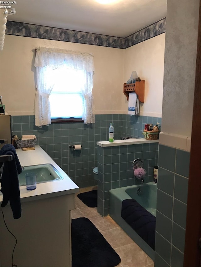 87 E Township Road 143, Tiffin, OH 44883 - bathroom with tile patterned floors, tile walls, a bath, double vanity, and wainscoting