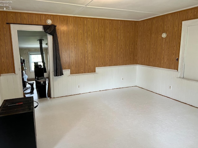 90 Newton St, Norwalk, OH 44857 - spare room featuring wood walls, a wainscoted wall, and a wood stove