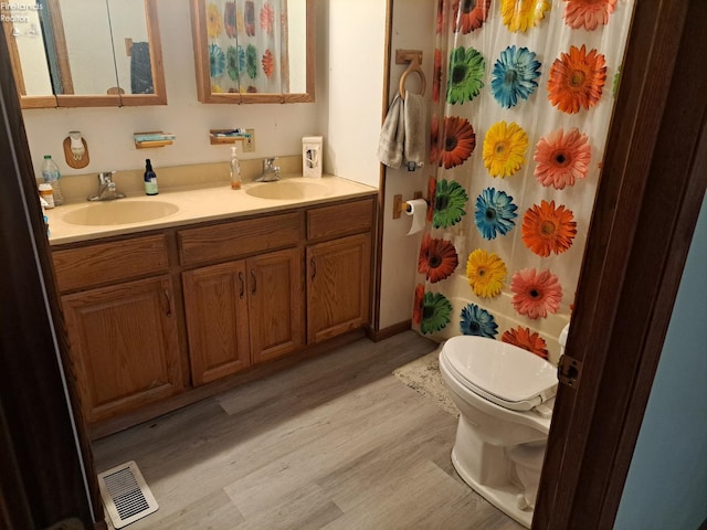 5890 E Sr 18, Republic, OH 44867 - full bath with wood finished floors, toilet, double vanity, and a shower with shower curtain