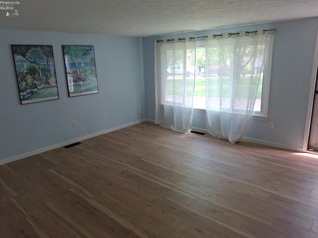 119 Michigan Ave, Huron, OH 44839 - spare room featuring wood finished floors, baseboards, and a textured ceiling