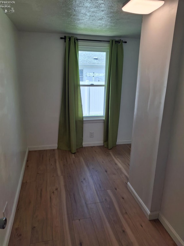 119 Michigan Ave, Huron, OH 44839 - unfurnished room featuring wood-type flooring, a textured ceiling, and baseboards