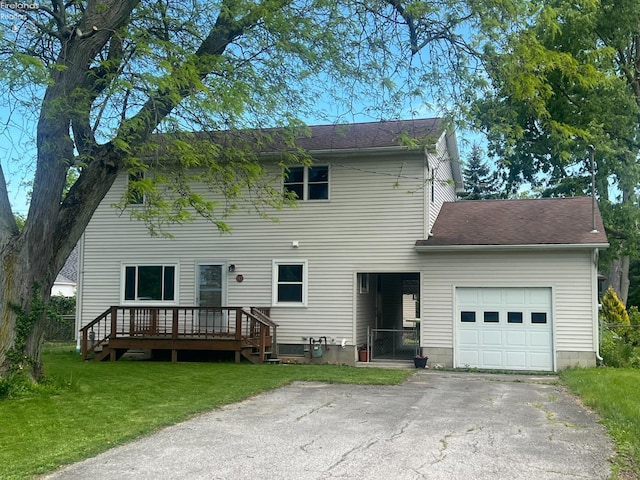 112 Dayton Ave, Huron, OH 44839 - rear view of property with a lawn, an attached garage, a shingled roof, asphalt driveway, and a deck