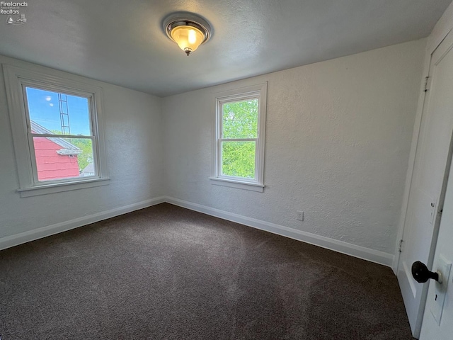 427 N Clover St, Fremont, OH 43420 - unfurnished room featuring baseboards, dark colored carpet, and a textured wall