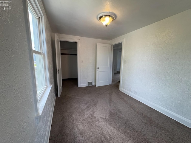 427 N Clover St, Fremont, OH 43420 - unfurnished bedroom with a textured wall, baseboards, carpet flooring, and a closet