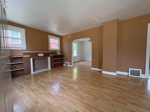 427 N Clover St, Fremont, OH 43420 - unfurnished living room with light wood finished floors, arched walkways, and baseboards