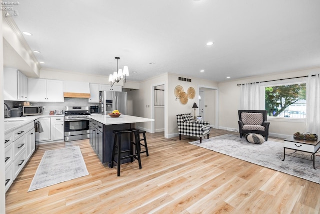 310 Linden Way, Sandusky, OH 44870 - kitchen featuring stainless steel appliances, light countertops, light wood-style floors, a kitchen island, and a breakfast bar area