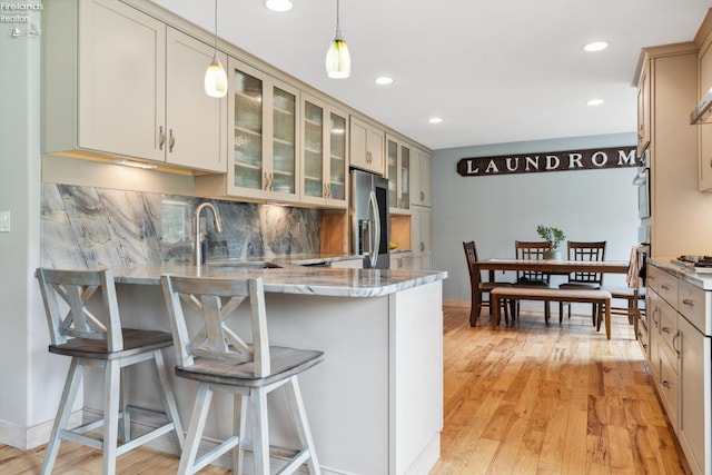 3999 NE Catawba Rd Unit 29, Port Clinton, OH 43452 - kitchen featuring stainless steel fridge, a sink, a peninsula, a kitchen breakfast bar, and light wood finished floors
