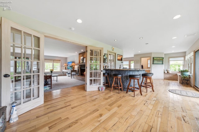 3999 NE Catawba Rd Unit 29, Port Clinton, OH 43452 - kitchen featuring light wood finished floors, a kitchen bar, recessed lighting, open floor plan, and a fireplace