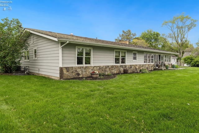 3999 NE Catawba Rd Unit 29, Port Clinton, OH 43452 - back of house featuring a yard, stone siding, and a chimney