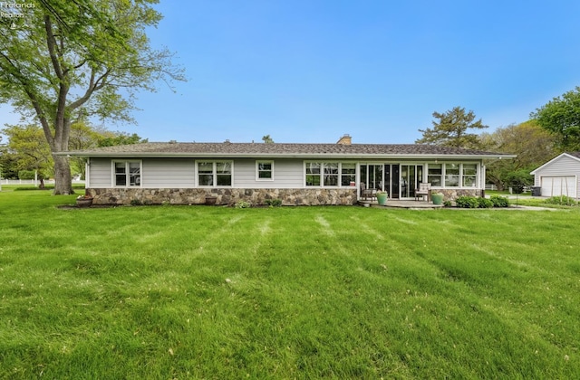3999 NE Catawba Rd Unit 29, Port Clinton, OH 43452 - rear view of house with stone siding, a chimney, a garage, and a yard