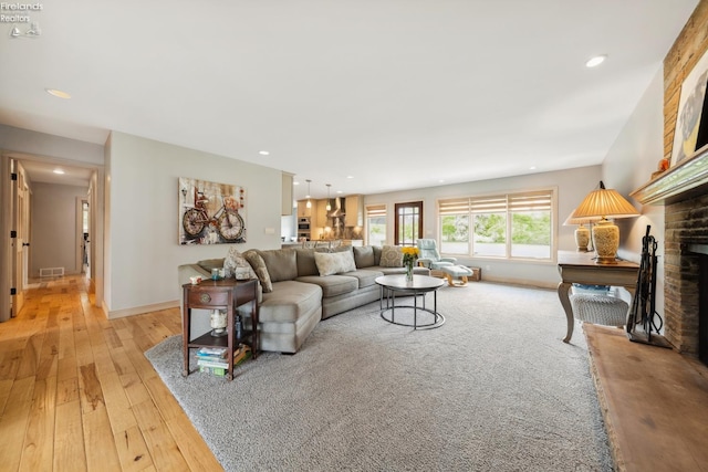 3999 NE Catawba Rd Unit 29, Port Clinton, OH 43452 - living area featuring a brick fireplace, recessed lighting, light wood-type flooring, and baseboards