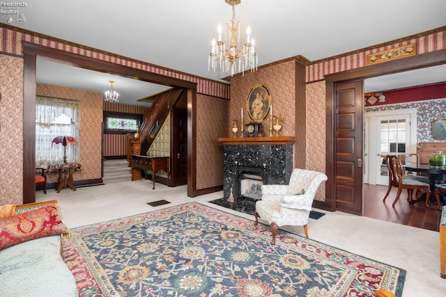 133 E Forest St, Clyde, OH 43410 - living area with wallpapered walls, a chandelier, stairway, carpet flooring, and plenty of natural light