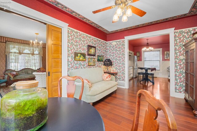 133 E Forest St, Clyde, OH 43410 - living room featuring a chandelier, wallpapered walls, wood finished floors, a ceiling fan, and baseboards