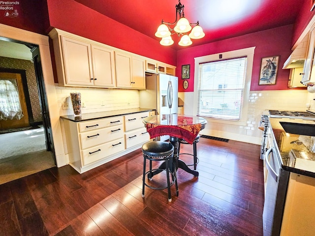 133 E Forest St, Clyde, OH 43410 - kitchen with stainless steel refrigerator with ice dispenser, dark wood finished floors, a chandelier, and dark countertops