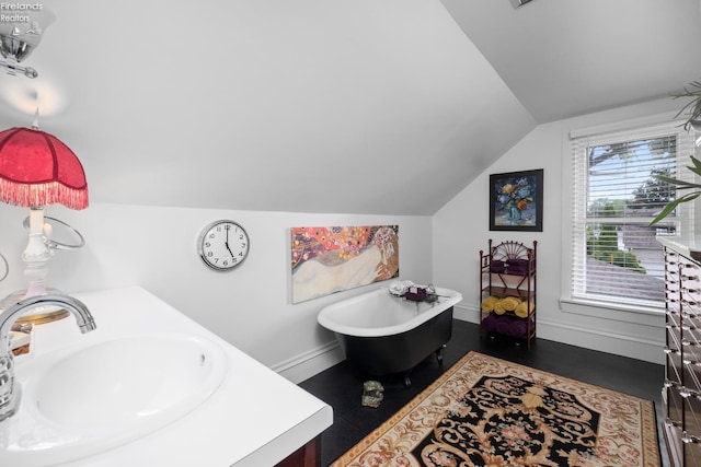133 E Forest St, Clyde, OH 43410 - bathroom with lofted ceiling, a soaking tub, baseboards, and double vanity