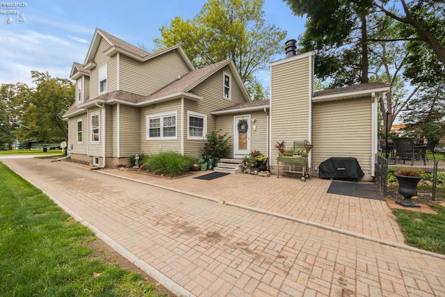 133 E Forest St, Clyde, OH 43410 - view of front of house with a chimney, a patio, and a shingled roof
