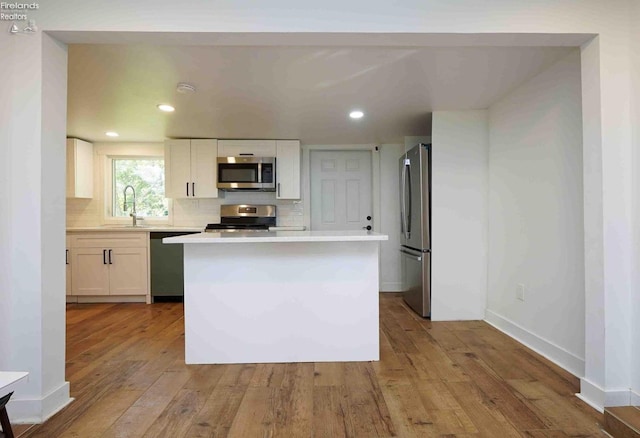 612 2nd St, Fremont, OH 43420 - kitchen with appliances with stainless steel finishes, light countertops, a sink, tasteful backsplash, and wood-type flooring