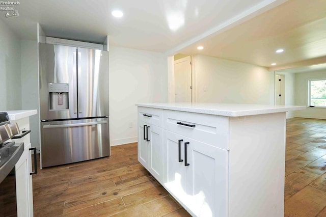 612 2nd St, Fremont, OH 43420 - kitchen with stainless steel refrigerator with ice dispenser, light wood-type flooring, recessed lighting, white cabinetry, and light countertops