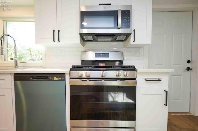 612 2nd St, Fremont, OH 43420 - kitchen with appliances with stainless steel finishes, light countertops, white cabinetry, backsplash, and a sink