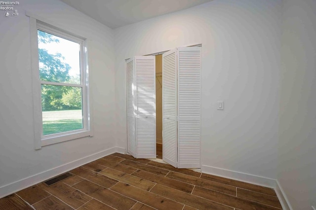 612 2nd St, Fremont, OH 43420 - unfurnished bedroom with dark wood-style flooring, multiple windows, baseboards, and a closet